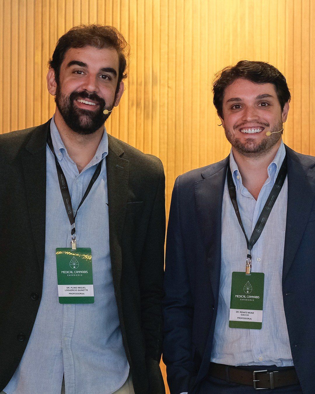 Dr. Plínio Miguel e Dr. Renato Giaccio lado a lado, sorrindo, com crachás do evento